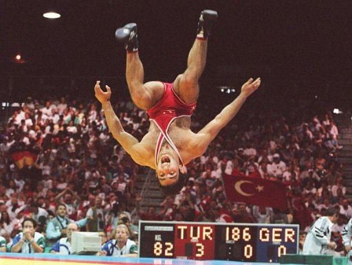 Turkey&#039;s Hamza Yerlikaya does a flip after beating Thomas Zander of Germany to gold in Olympic wrestling on 21 July 1996
