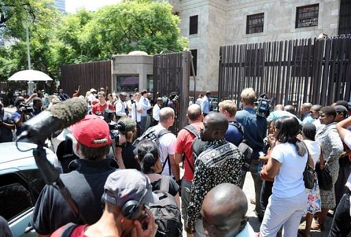 Reporters wait on February 15, 2013 outside the Magistrate Court in Pretoria for  Oscar Pistorius to leave the building