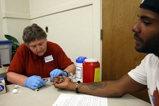 Nurse Dianne Wash takes a blood sample from Keri Anderson at a routine medical check in Los Angeles on July 10, 2012