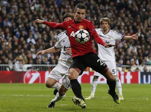 Manchester United&#039;s Robin van Persie keeps Real Madrid players at bay during the match  in Madrid on February 13, 2013