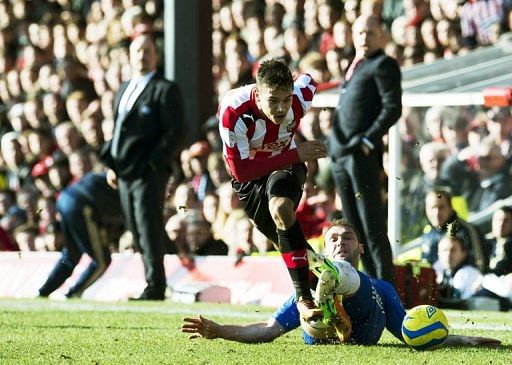 Brentford&#039;s Harry Forrester (C) gets tackled by Chelsea&#039;s Branislav Ivanovic, at Griffin Park, on January 27, 2013