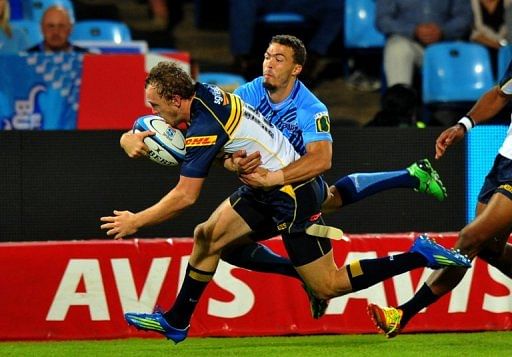 ACT Brumbies fullback Jesse Mogg (L) is tackled during a Super 15 rugby union match in Pretoria on April 21, 2012