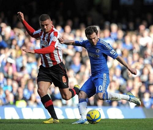 Chelsea's Juan Mata (right) shoots past Brentford's Harlee Dean to score the opening goal on February 17, 2013 Chelsea's Juan Mata (right) shoots past Brentford's Harlee Dean to score the opening goal on February 17, 2013