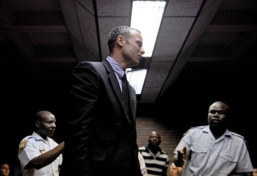 Oscar Pistorius leaves a Pretoria courtroom on February 15, 2013 after his hearing on charges of murdering his girlfriend