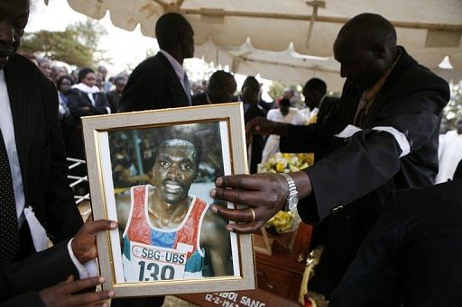 A Kenyan runner (R) gives a portrait of Lucas Lang to one of his sons during Sang&#039;s funeral, on January 10, 2008