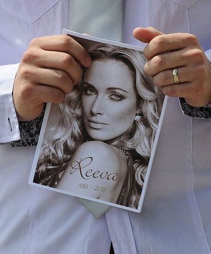 A relative of the late South African model Reeva Steenkamp holds the funeral program on February 19, 2013