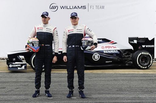 Pastor Maldonado (left) and Valtteri Bottas pose in front of the new Williams car in Montmelo on February 19, 2013