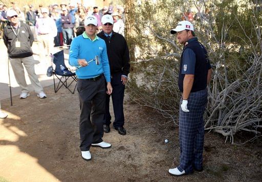 Graeme McDowell (R) explains to Alexander Noren why he needs to take a dropshot, on February 22, 2013