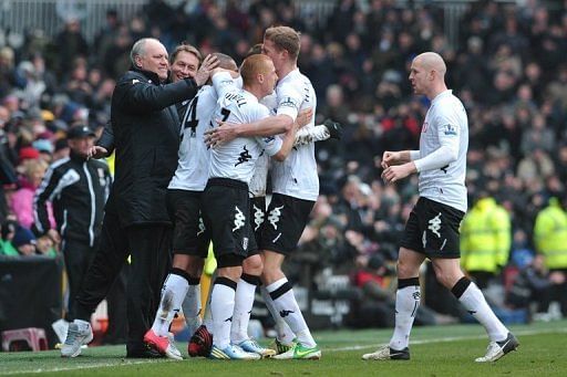 Fulham boss Martin Jol (L) celebrates with his players after Dimitar Berbatov&#039;s goal against Stoke on February 23, 2013