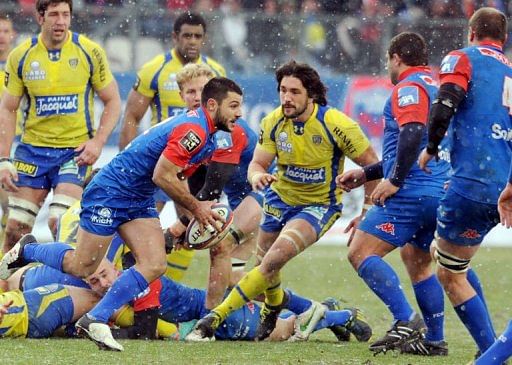Grenoble&#039;s fly-half Jonathan Pelissie (L) runs with the ball  against Clermont on February 23, 2013 in Grenoble