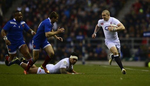 England&#039;s wing Mike Brown (R) runs with the ball at Twickenham Stadium in south-west London on February 23, 2013