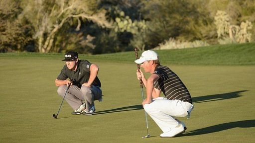 Hunter Mahan (L) and Webb Simpson line up their putts during the quarter-final on February 23, 2013