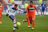 Lyon's Steed Malbranque (L) keeps the ball away from Lorient's Arnaud Le Lan on February 24, 2013
