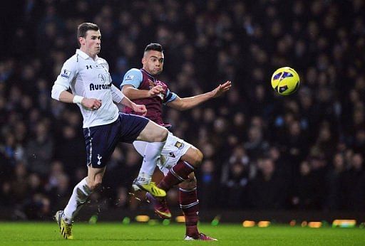Tottenham winger Gareth Bale (L) challenges West Ham&#039;s Winston Reid on February 25, 2013