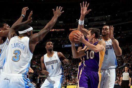 Steve Nash of the Los Angeles Lakers looks to pass the ball against the Denver Nuggets defense on February 25, 2013