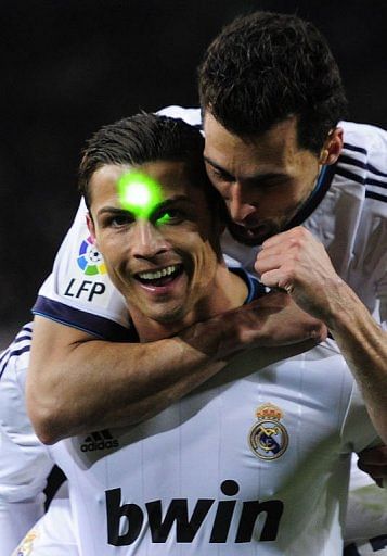 Real Madrid&#039;s Cristiano Ronaldo is lit with a green laser at the Camp Nou stadium in Barcelona on February 26, 2013