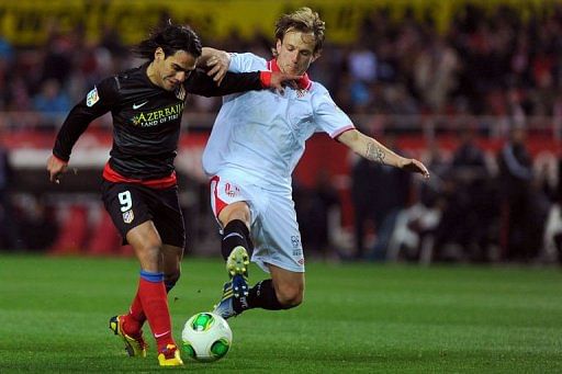 Atletico Madrid&#039;s Radamel Falcao (L) vies with Sevilla&#039;s Ivan Rakitic in Sevilla on February 27, 2013
