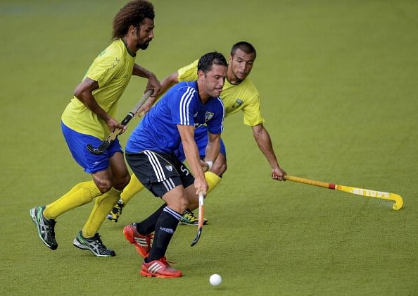 RIO DE JANEIRO, BRAZIL - FEBRUARY 28: Eduardo Raimundo (L) and Afonso Motta of Brazil fights for the ball with Pedro Ibarra of Argentina during the match between Brazil and Argentina as part of Hockey World League - Round 2 at Complexo Esportivo de Deodoro