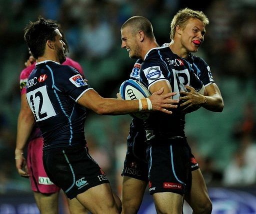 Waratahs&#039; Robert Horne (C) is congratulated by teammates after scoring a try against Bulls, in Sydney, on May 11, 2012