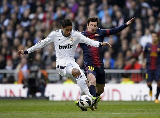 Real Madrid&#039;s Raphael Varane clashes with Barcelona&#039;s Lionel Messi in Madrid, March 2, 2013