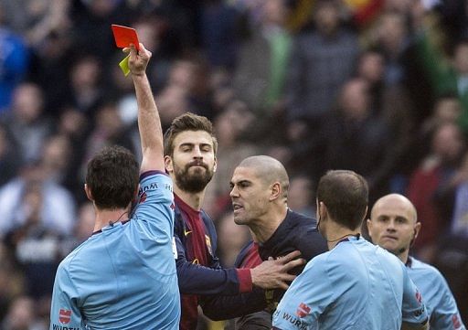 Barcelona goalkeeper Victor Valdes (C) gets a red card from referee Perez Lasa in Madrid on March 2, 2013