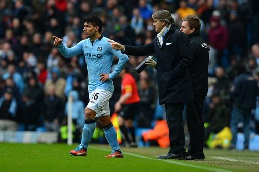 Manchester City&#039;s Roberto Mancini (R) talks to Sergio Aguero during their match against Chelsea on February 24, 2013