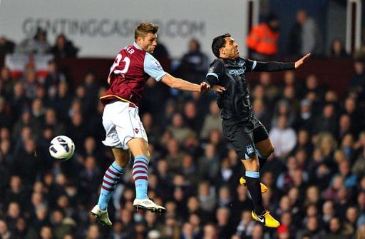 Manchester City&#039;s Carlos Tevez (R) jumps with Aston Villa&#039;s Nathan Baker in Birmingham on March 4, 2013