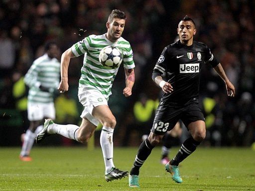 Celtic&#039;s Charlie Mulgrew (L) vies with Arturo Vidal of Juventus during the first leg at Celtic Park on February 12, 2013