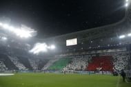Supporters wave flags under an heavy rain prior to the match on March 6, 2013 at the