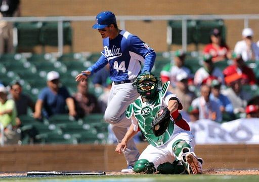 Humberto Cota of Mexico catches the ball late as Anthony Rizzo of Italy safely scores March 7, 2013 in Scottsdale