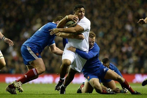 Mako Vunipola (centre) is tackled during a rugby match between England and France in London on February 23, 2013