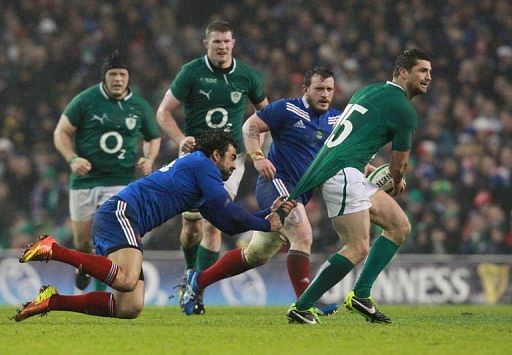 Ireland&#039;s Rob Kearney (R) is tackled by France&#039;s  Yoann Huget (L) and Yoann Huget (C), March 9, 2013