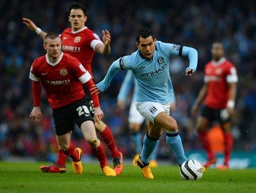 Manchester City forward Carlos Tevez gets away from Barnsley&#039;s Ryan Tunnicliffe on March 9, 2013