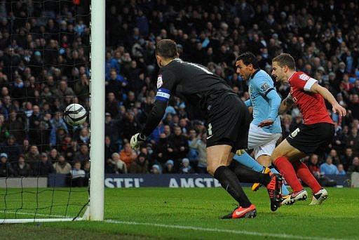 Manchester City forward Carlos Tevez scores the opening goal against Barnsley on March 9, 2013