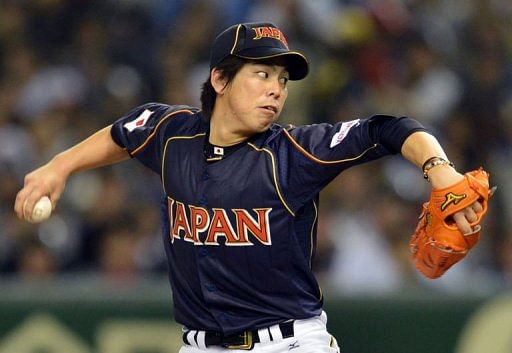 Japan&#039;s starting pitcher Kenta Maeda throws the ball against the Netherlands at Tokyo Dome on March 10, 2013
