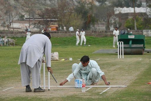 Ground staff prepare a pitch in northwest Swabi, the hometown of a Pakistani cricketer Fawad Ahmed on March 9, 2013