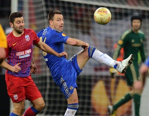 John Terry (R) hooks the ball clear against  Steaua Bucharest on March 7, 2013