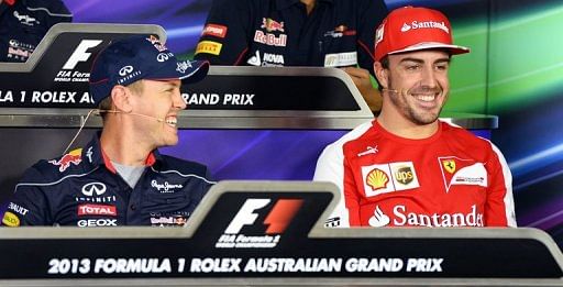 Sebastian Vettel (L) shares a lighter moment with rival Fernando Alonso at a press conference on March 14, 2013