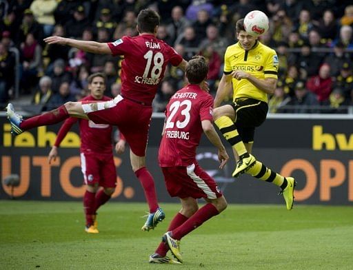 Dortmund&#039;s striker Robert Lewandowski (R) heads to score in Dortmund on March 16, 2013