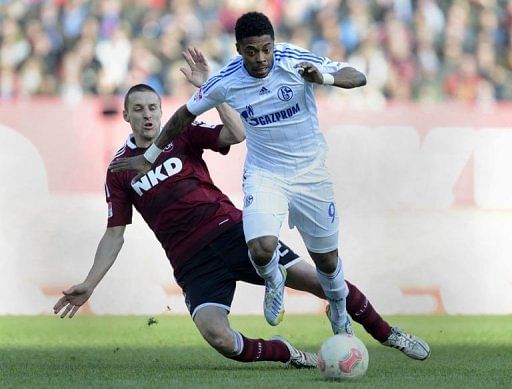 Schalke&#039;s Michel Bastos (R) and Nuremberg&#039;s Timmy Simons fight for the ball, March 16, 2013 in Nuremberg