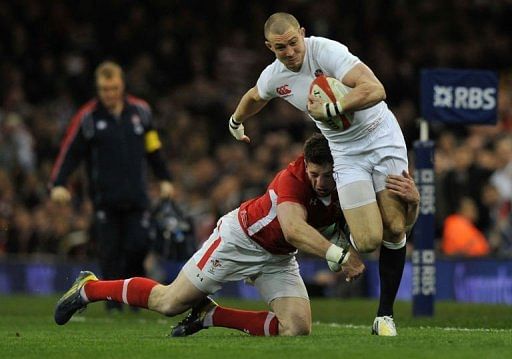 England&#039;s wing Mike Brown (R) is tackled in Cardiff, on March 16, 2013