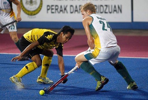 Faizal Saari (left) fights for the ball with Christopher Bausor in Ipoh on March 17, 2013.