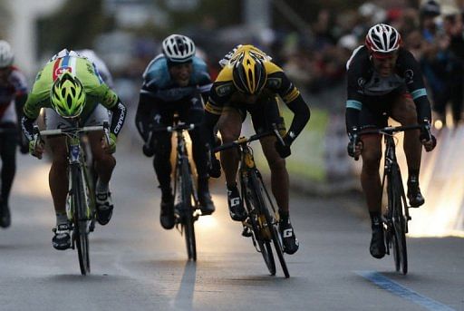 Gerald Ciolek (yellow) crosses the finish line to win the 104th Milan San Remo spring classic on March 17, 2013