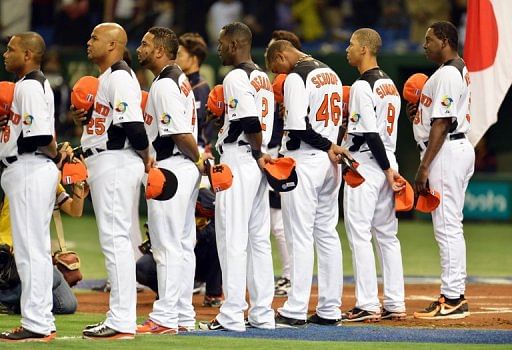 Netherlands manager Hensley Meulens (R) and players listen to the national anthem ahead of a WBC game on March 10, 2013