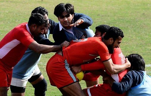 Local Pakistani rugby players fight for the ball during a match between the Army and the Lahore team, February 24, 2013