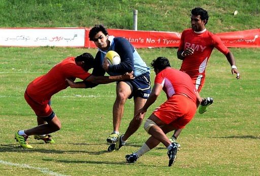 A Lahore player tries to ride the tackles of the Army team, on February 24, 2013