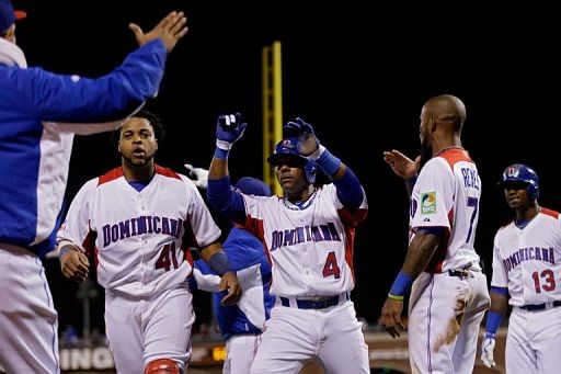 Miguel Tejada (C) celebrates with Carlos Santana (L) and Jose Reyes after scoring in the fifth inning on March 18, 2013