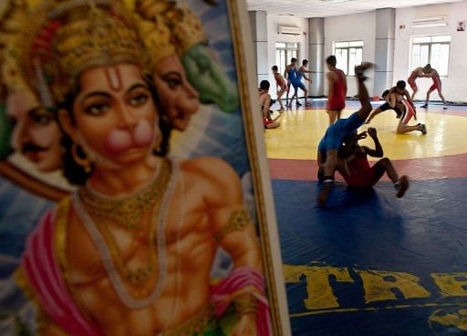 Young Indian wrestlers train next to a picture of Hindu monkey-god Lord Hanuman, in New Delhi, on March 4, 2013