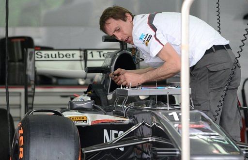 A crew member prepares Nico Hulkenberg&#039;s car ahead for the Formula One Malaysian Grand Prix at Sepang on March 21, 2013