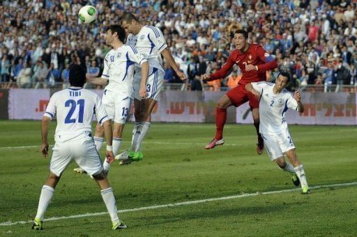 Portuguese forward Cristiano Ronaldo (R) goes up for a high ball against a packed Israel defence on March 22, 2013